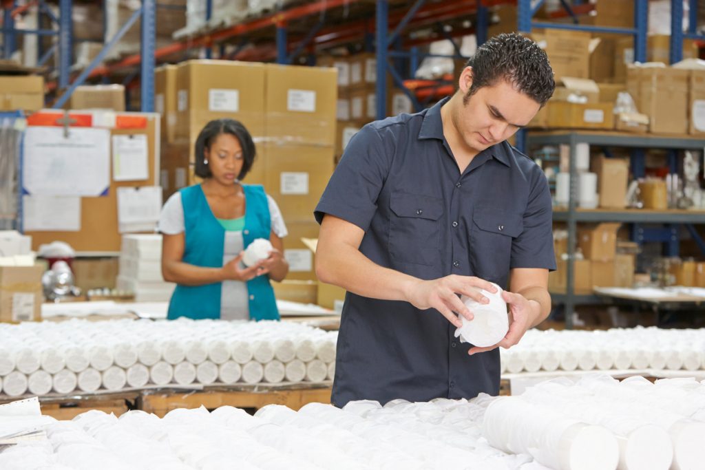Trabajador hispano en cadena de producción en una fábrica para ilustrar la idea de Costos de producción