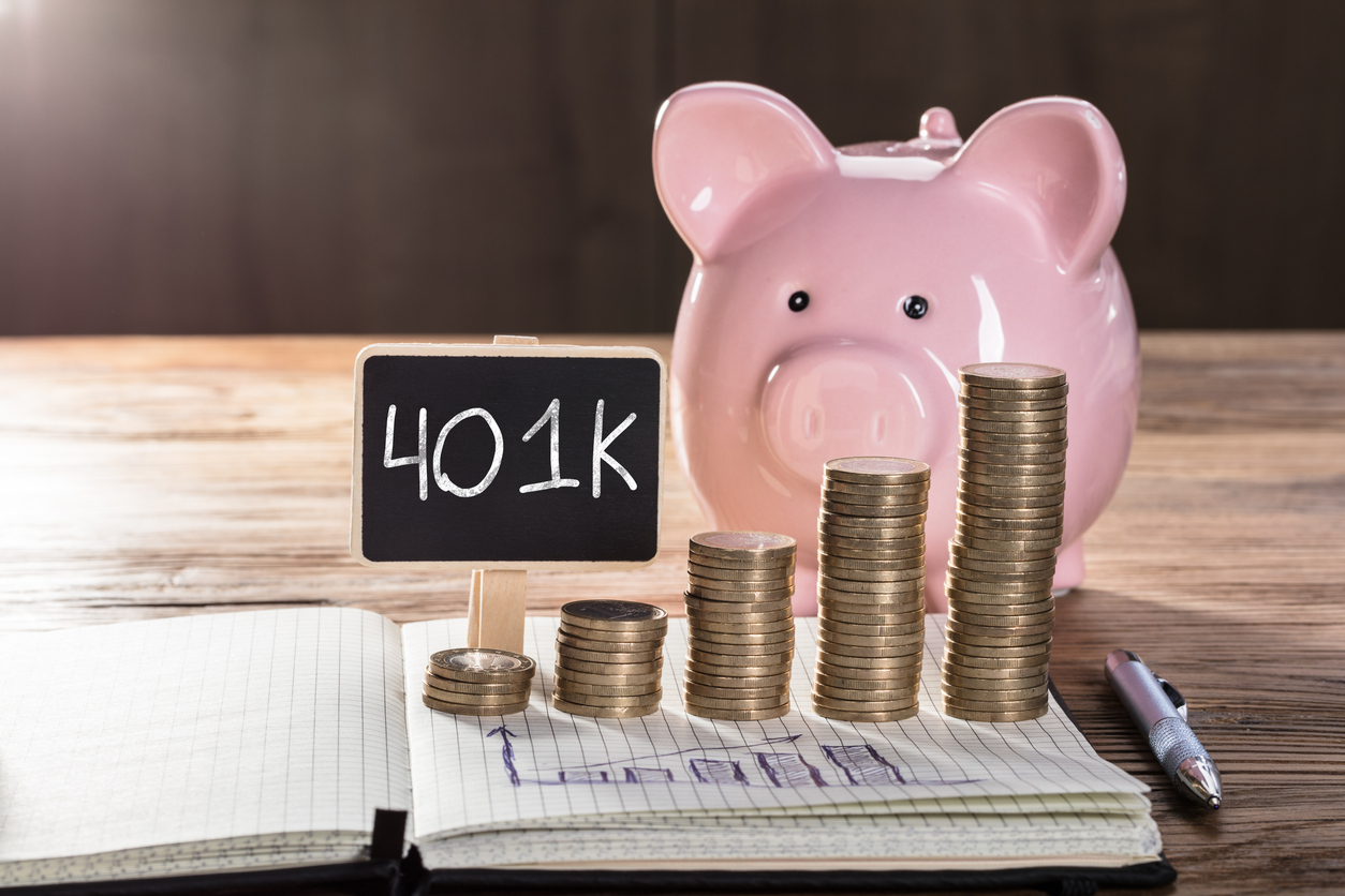 401(k) Concept With Piggybank, Coin Stacked, And Graph On Notebook Over The Wooden Table