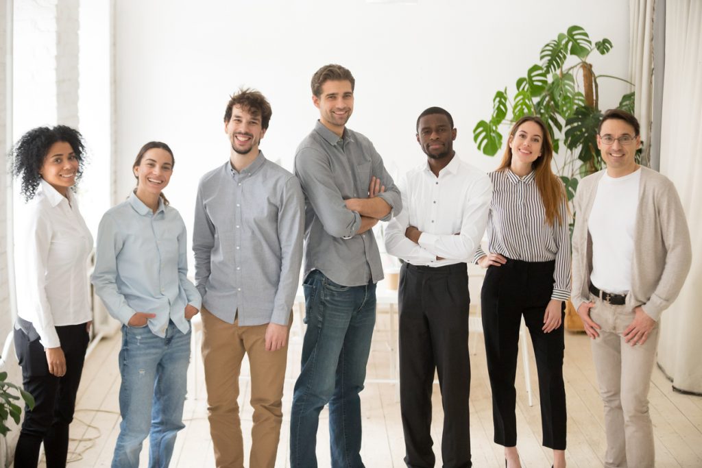 Young happy multiracial professionals or company staff looking at camera smiling. Concept: employees' salary