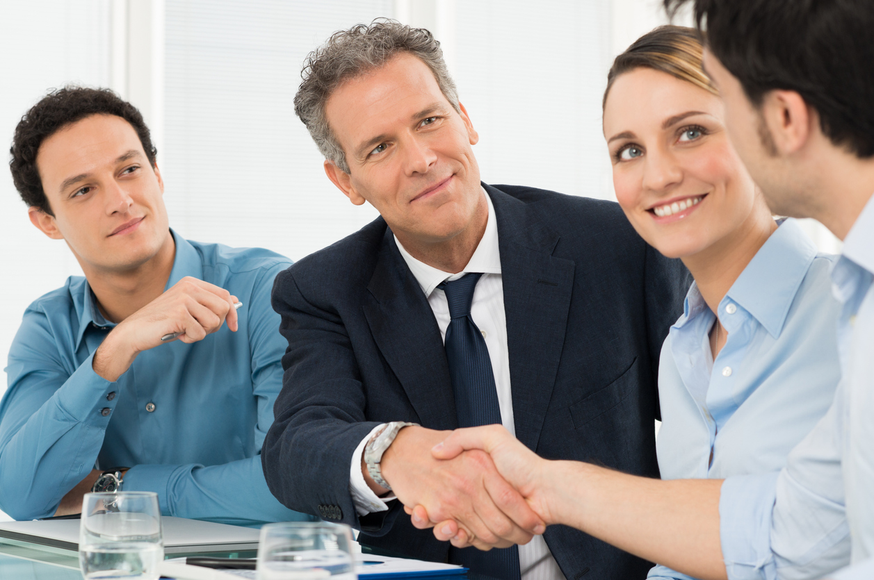 Two Successful Businessmen Shaking Hands In Front Of Their Colleague. Concept: supplier contracts