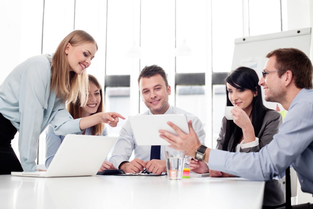 Group of business people working with digital tablet in office. Concept: How to set up an LLC