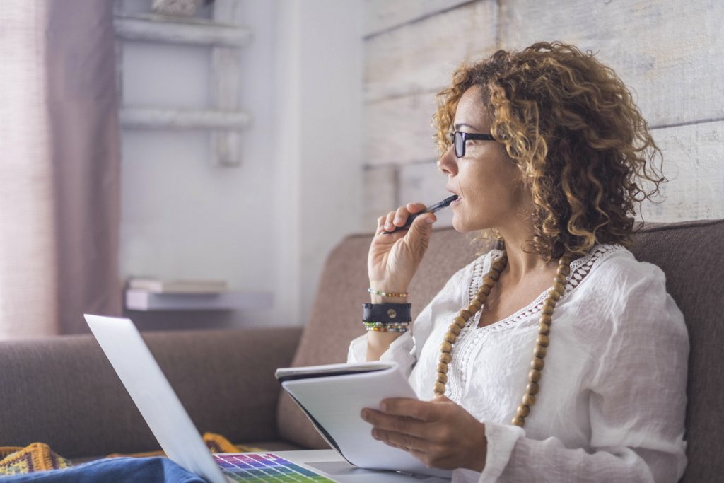 Dueña de una empresa con bloqueo creativo trata de pensar en temas para escribir en su blog para empresas. Concept: ¿Sobre qué deberías escribir en el blog de tu negocio?