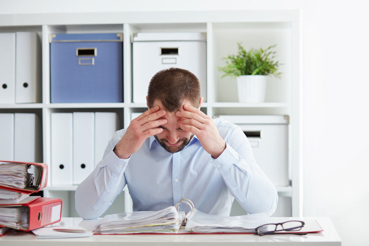 Young business owner at desk under stress. Concept: File for bankruptcy