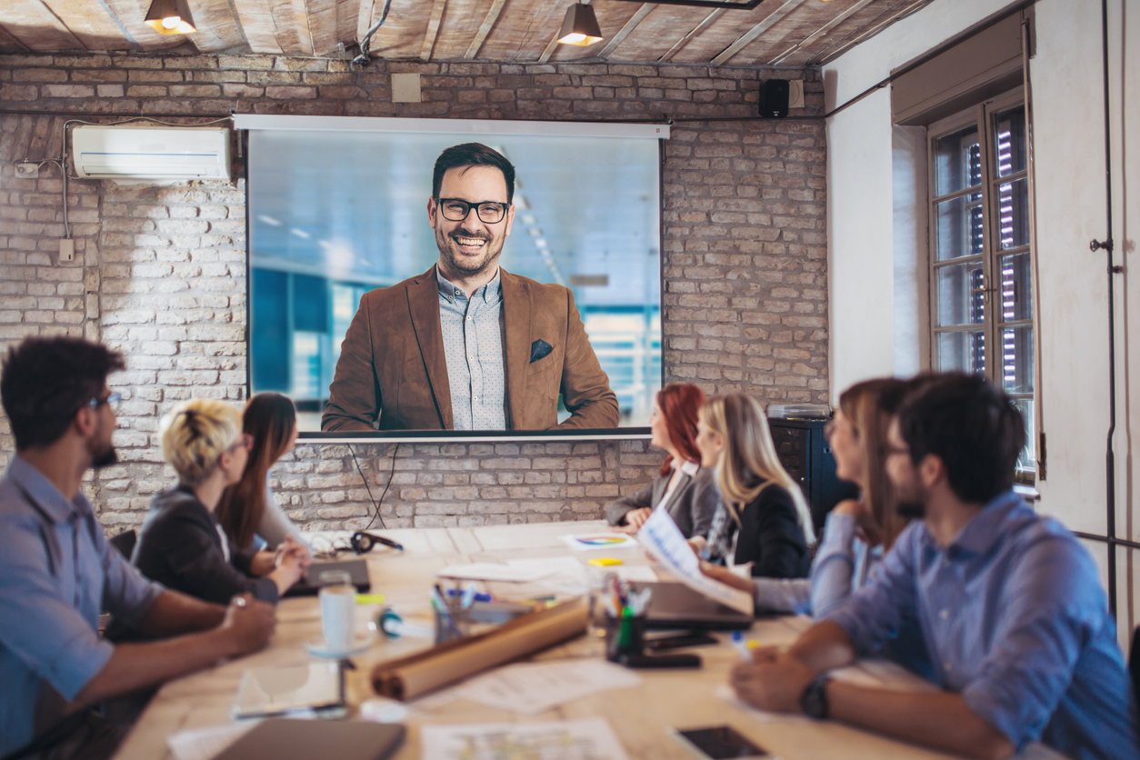 Business people looking at projector during video conference in their office. Concept: how to use skype for business