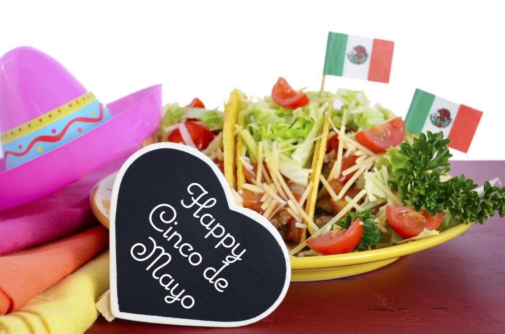Plato y decoraciones mexicanas con la leyenda: Feliz Cinco de Mayo.
