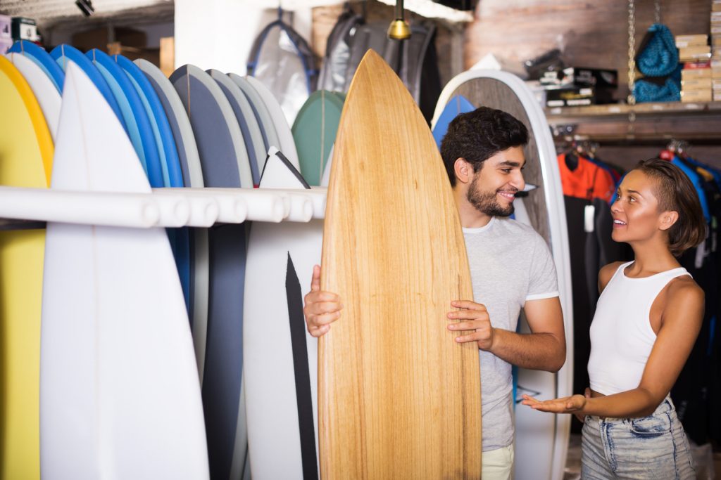 Adult man and woman at their surfboard seasonal busness. Concept: best cities for seasonal businesses