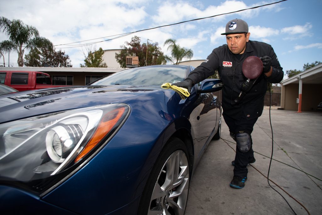 Ángel Rojas working on a car for his detail service businessin Los Angeles. Concept: Success Story: Ángel Rojas, Security and Efficiency Above All