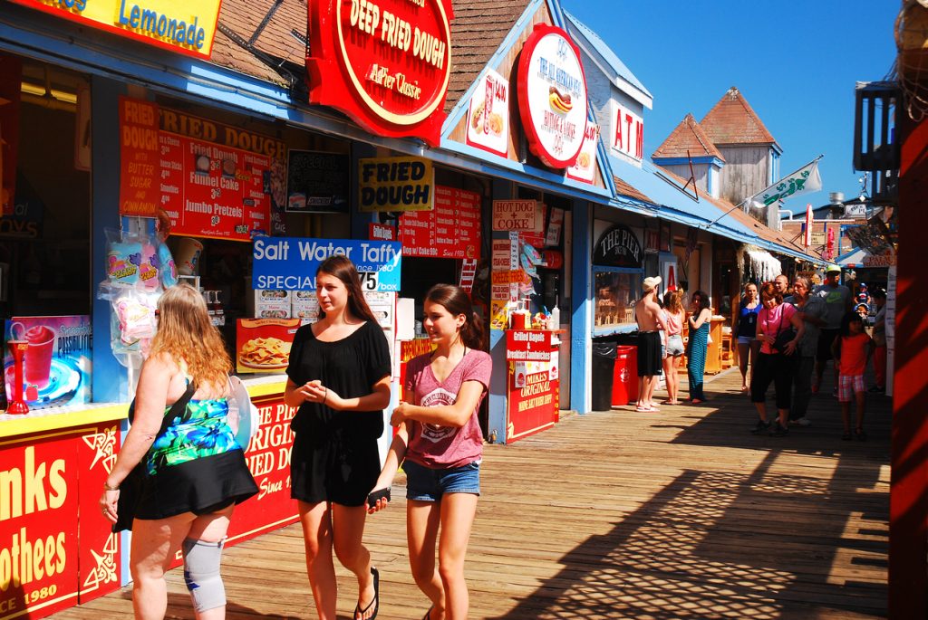People on boardwalk during summertime. Concept: summer sales
