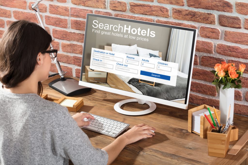 Mujer en camputadora haciendo una reserva de hotel. Concepto: Software de reservas en línea