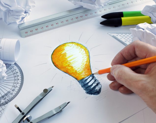 Diseñador dibujando una bombilla. Concepto: Publicidad creativa para tu pequeña empresa