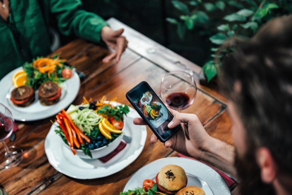 Man Photographing Food In A Restaurant. Concept: Social media for restaurants