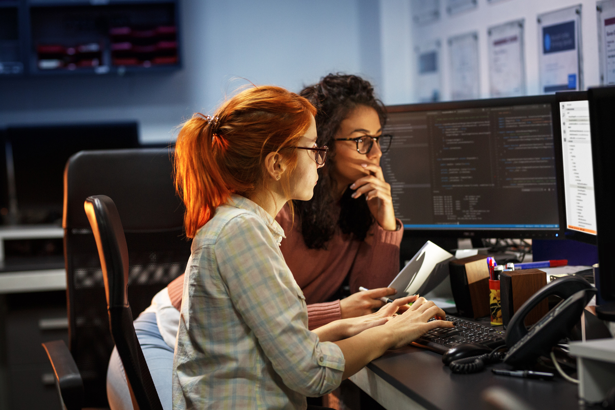 Two female programmers working on project. Concept: How to protect your small business against hackers