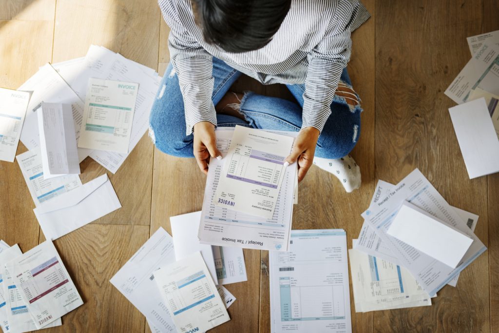 Woman managing multiple debts and invoices. Concept: Debt consolidation loans