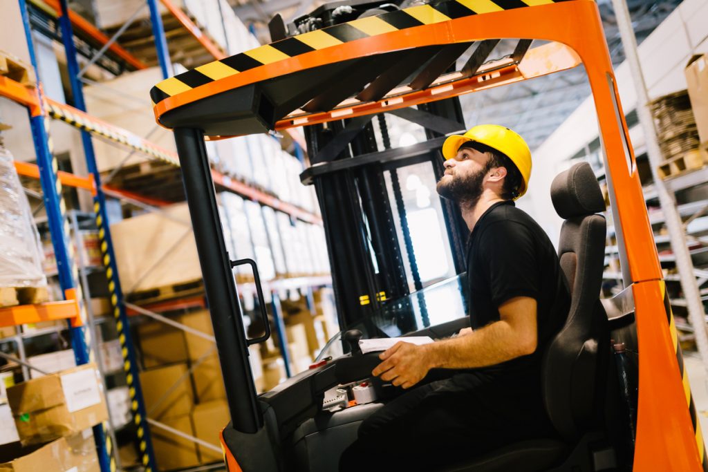 Warehouse industry worker doing logistics work with forklift loader. Concept: equipment budget