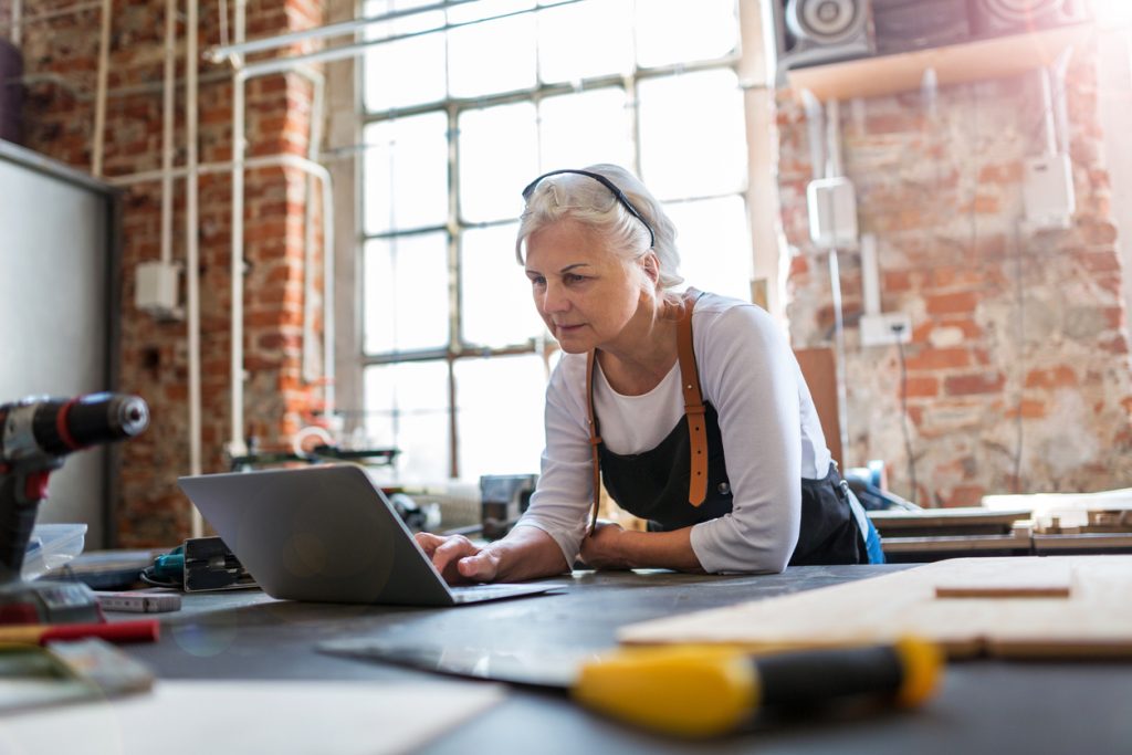 Workshop owner using a laptop. Concept: budgeting for small business