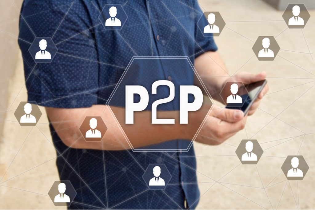 Peer-to-peer lending: P2P on the touch screen with a blur background of the businessman with the phone.