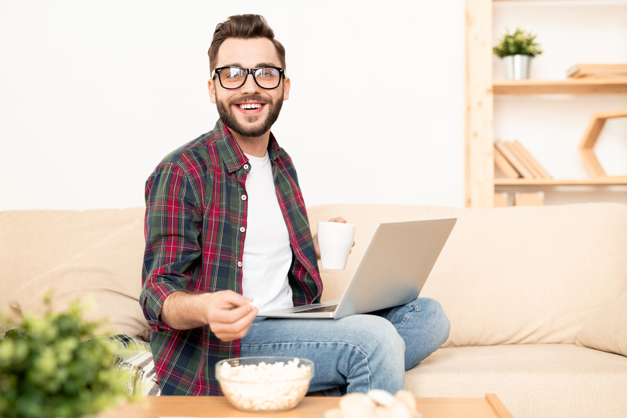 Solopreneur working on laptop on couch at home. Concept: tips for solopreneurs