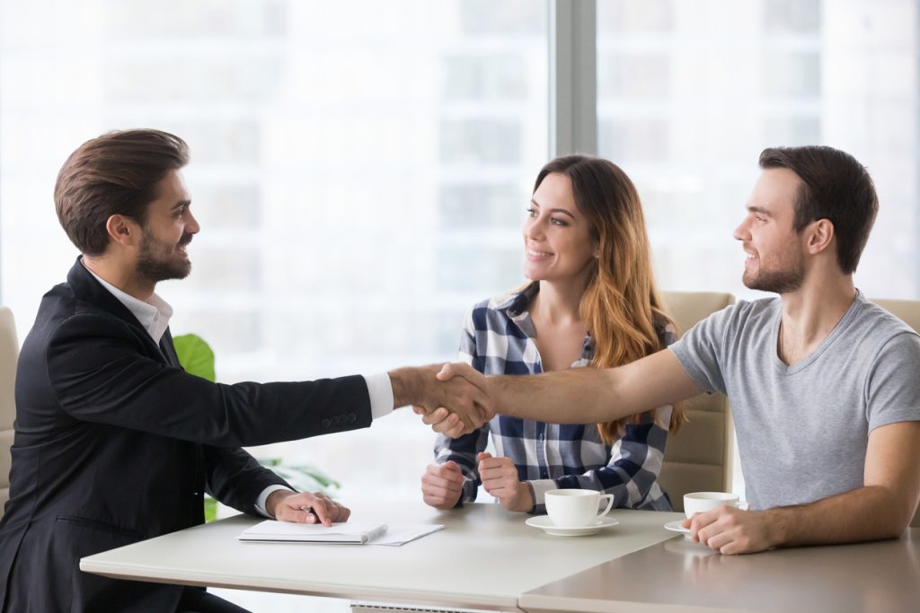 Bank customeres shaking hands with bank representative. Concept: Microloans vs personal loans