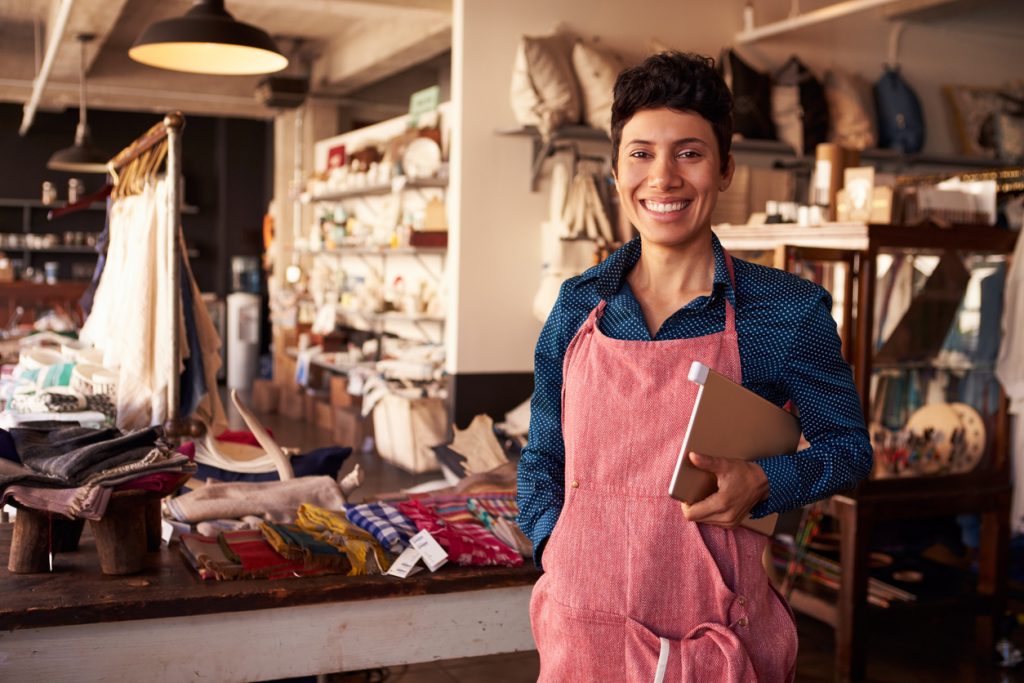 Portrait Of Female Owner Of Gift Store With Digital Tablet. Microloan vs payday loan