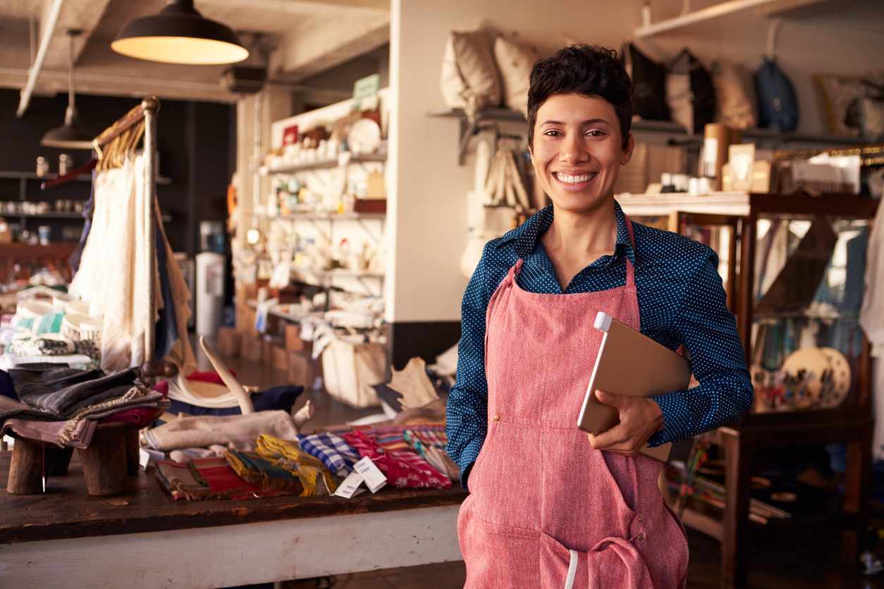 Portrait Of Female Owner Of Gift Store With Digital Tablet. Microloan vs payday loan