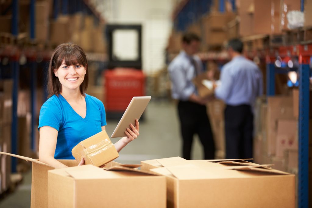 Worker In Warehouse Checking Boxes. Concept: profit margin