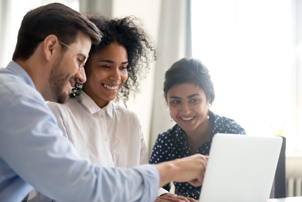 Trabajadores diversos en una oficina revisando una computadora. Concept: software de facturación