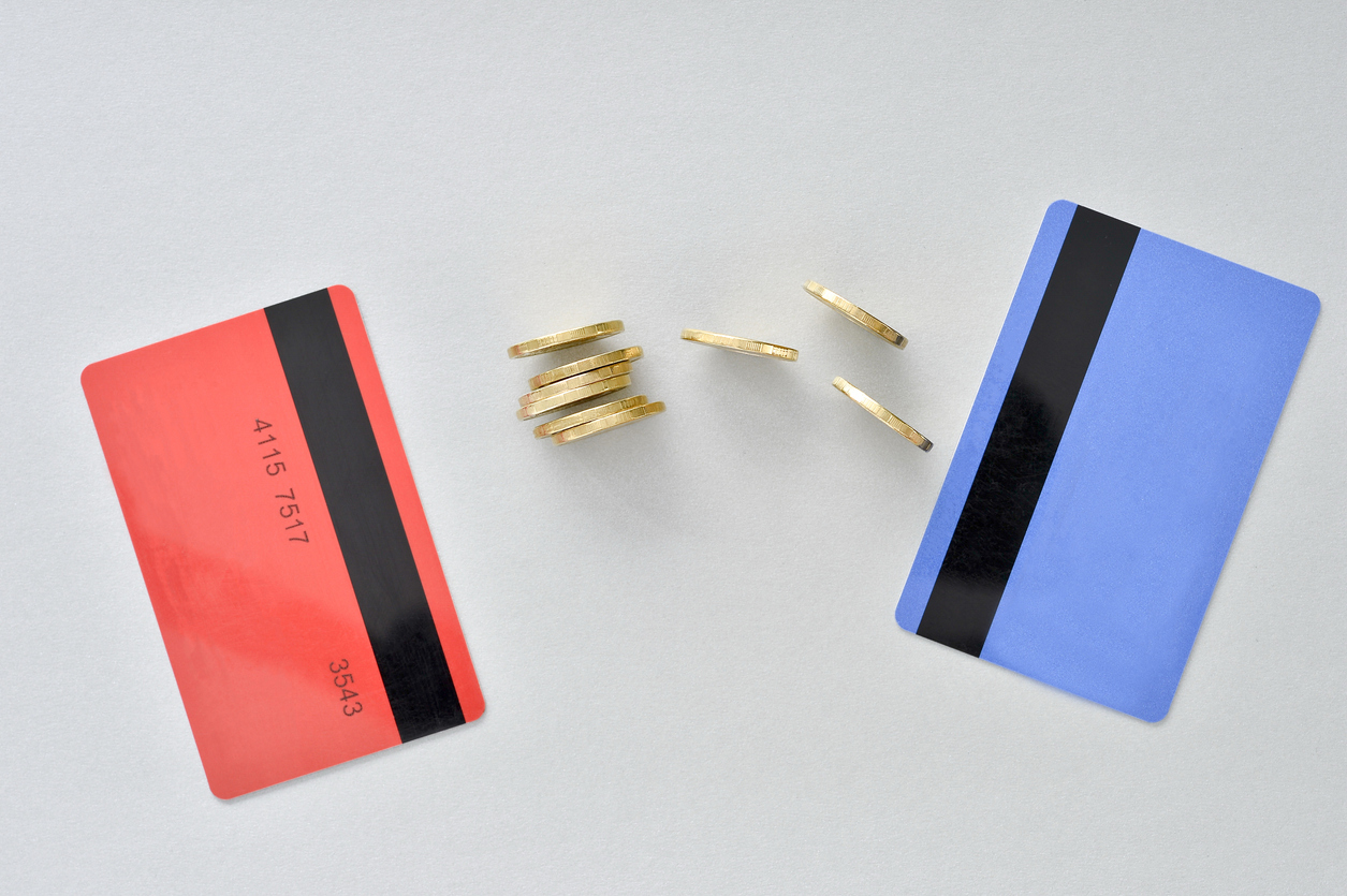 Bank cards are in the colors of living coral and blue with shiny yellow coins symbolizing the electronic exchange of money. Concept: What is Balance Transfer?