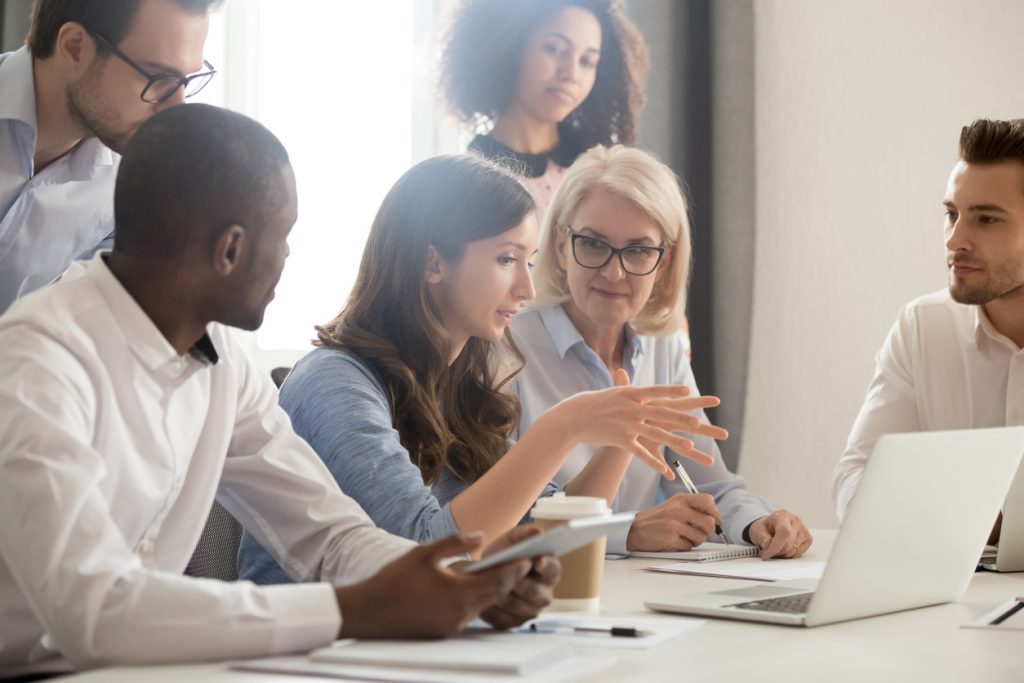 Joven consultora profesional entrenando a empleados en oficina. Concepto: ¿Cómo comenzar un negocio de consultoría?