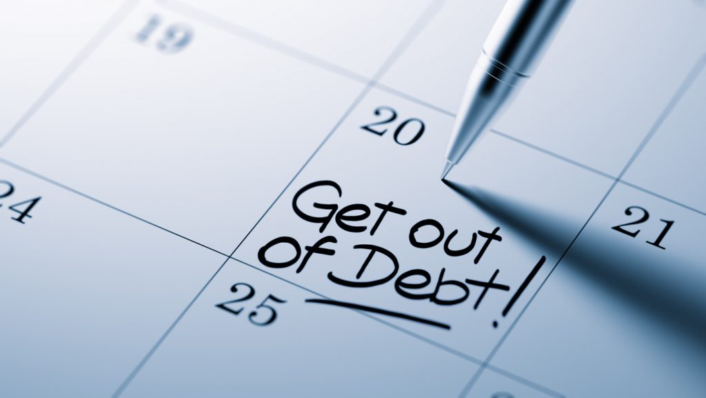 Closeup of a personal agenda setting an important date written with pen. The words Get out of debt written on a white notebook to remind you an important appointment. concept: Debt Management Program