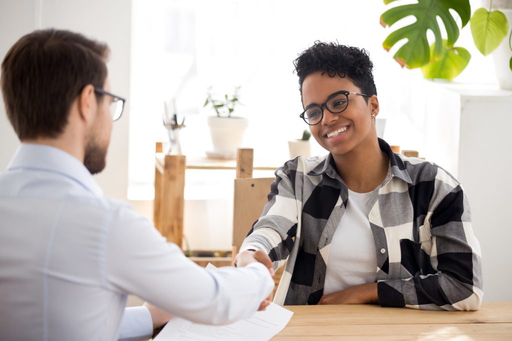 Borrower with lender at bank office applying for loan and agreeing on a loan origination fee.