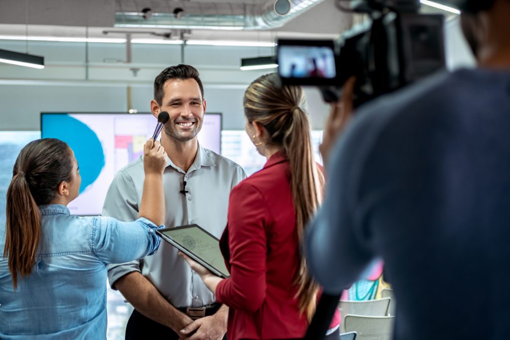 Dueño de negocio siendo filmado en anuncio de televisión. Concepto: Cómo anunciar tu negocio en televisión