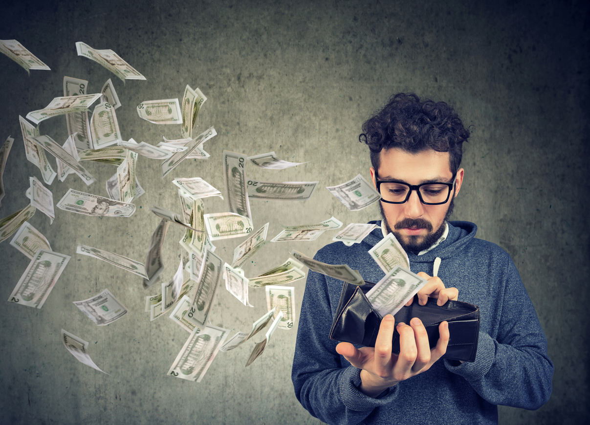 Sad man looking at his wallet with money dollar banknotes flying out away. Concept: prepayment penalty