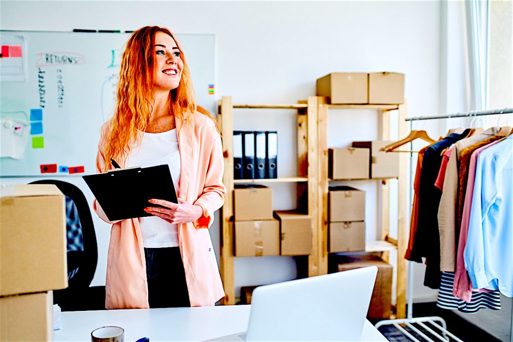 Small online clothing store owner proudly standing in office space and looking away. Concept: small business loan 2020