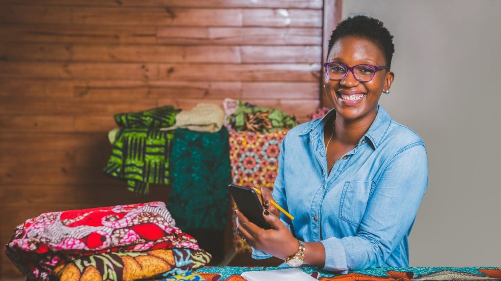 African-American Female Fashion Designer with mobile phone. concept: what is a SKU number