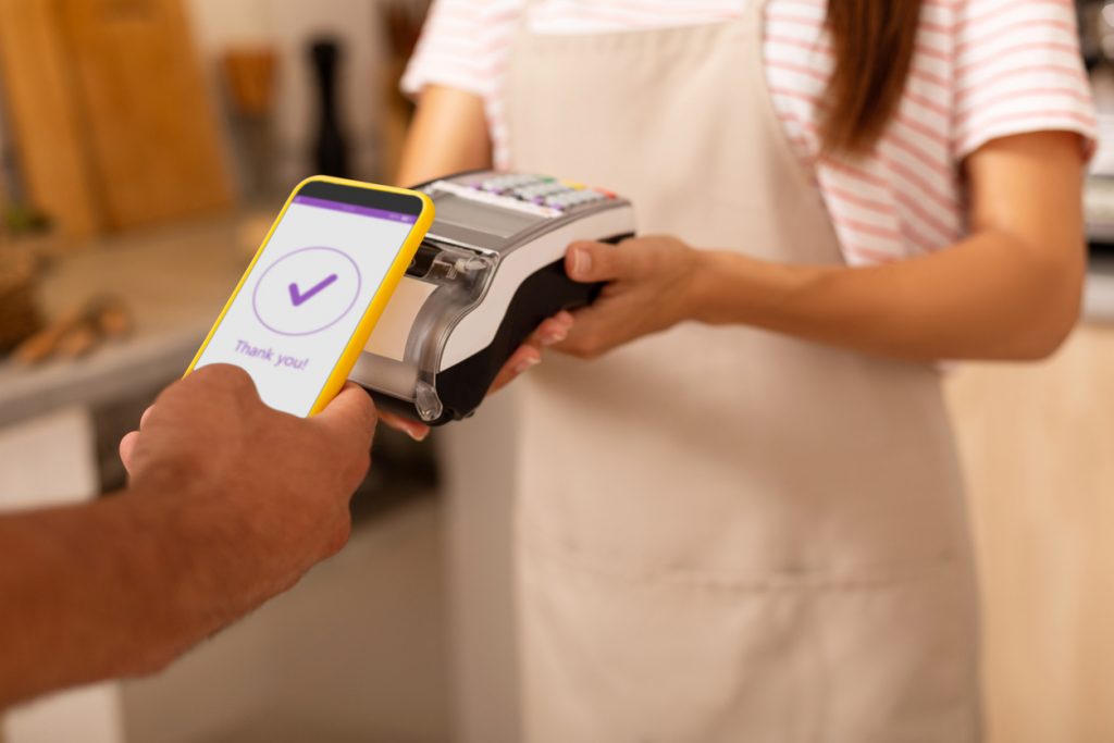 Pago con celilcar. Persona pagando servicios con su celular. Concept: square o paypal