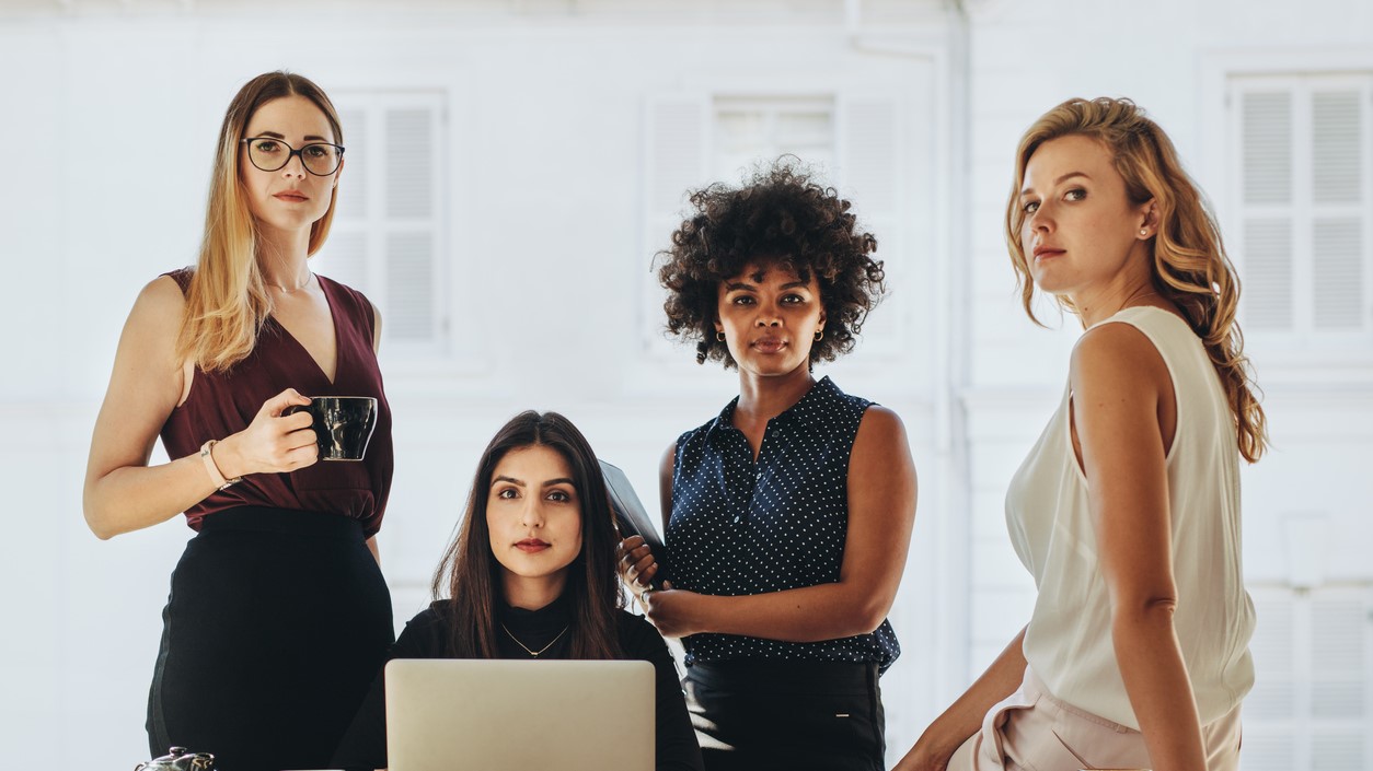 Group of multiracial businesswomen in casuals together at office desk and looking at camera. Female startup business team portrait. concept_ Business Magazines for Women