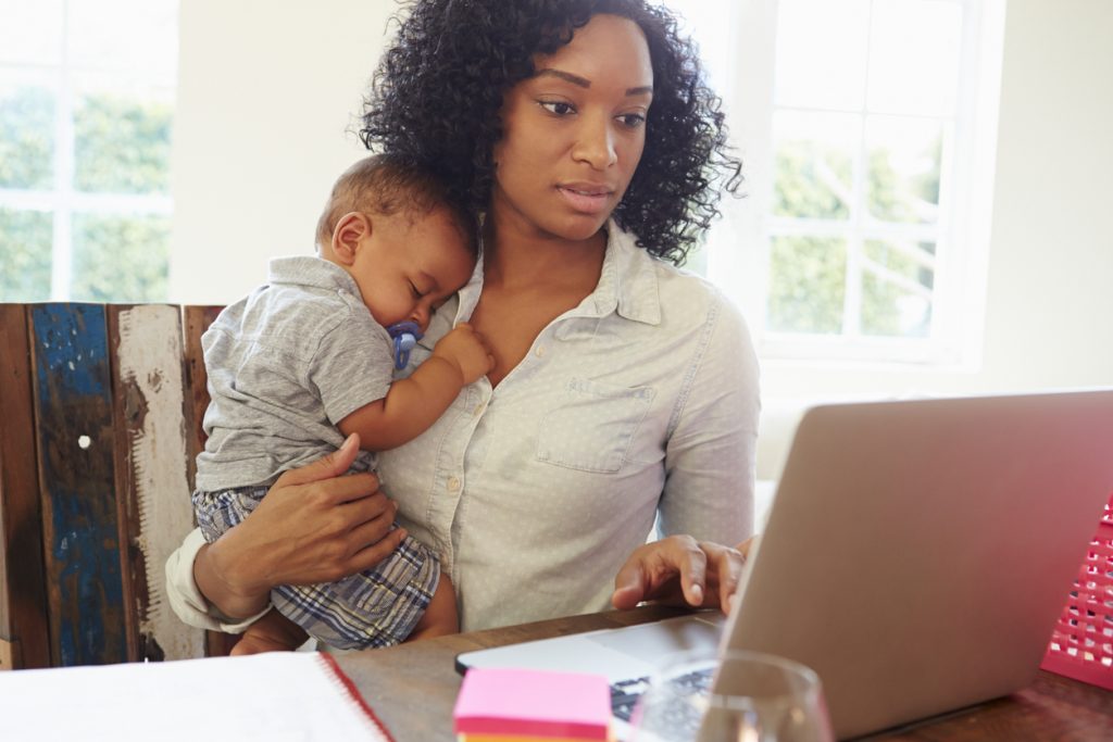 Mother With Baby Working In Office At Home Looking At Laptop. Concept: business ideas for mompreneurs