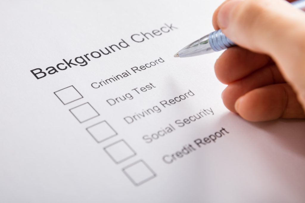 Close-up Of Person Hand Filling Background Check Form. concept: software de verificación de antecedentes