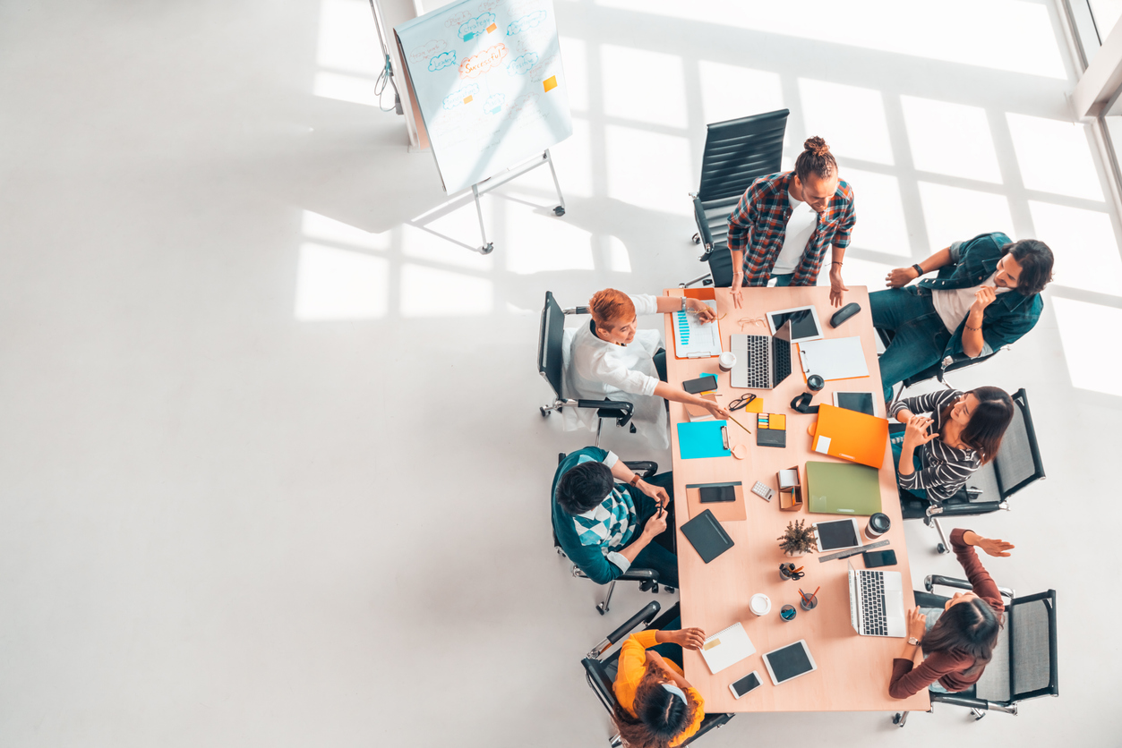 Multiethnic diverse group of business coworkers in team meeting discussion, top view modern office with copy space. Partnership professional teamwork, startup company, or project brainstorm. concept: Small Business Consulting Firm