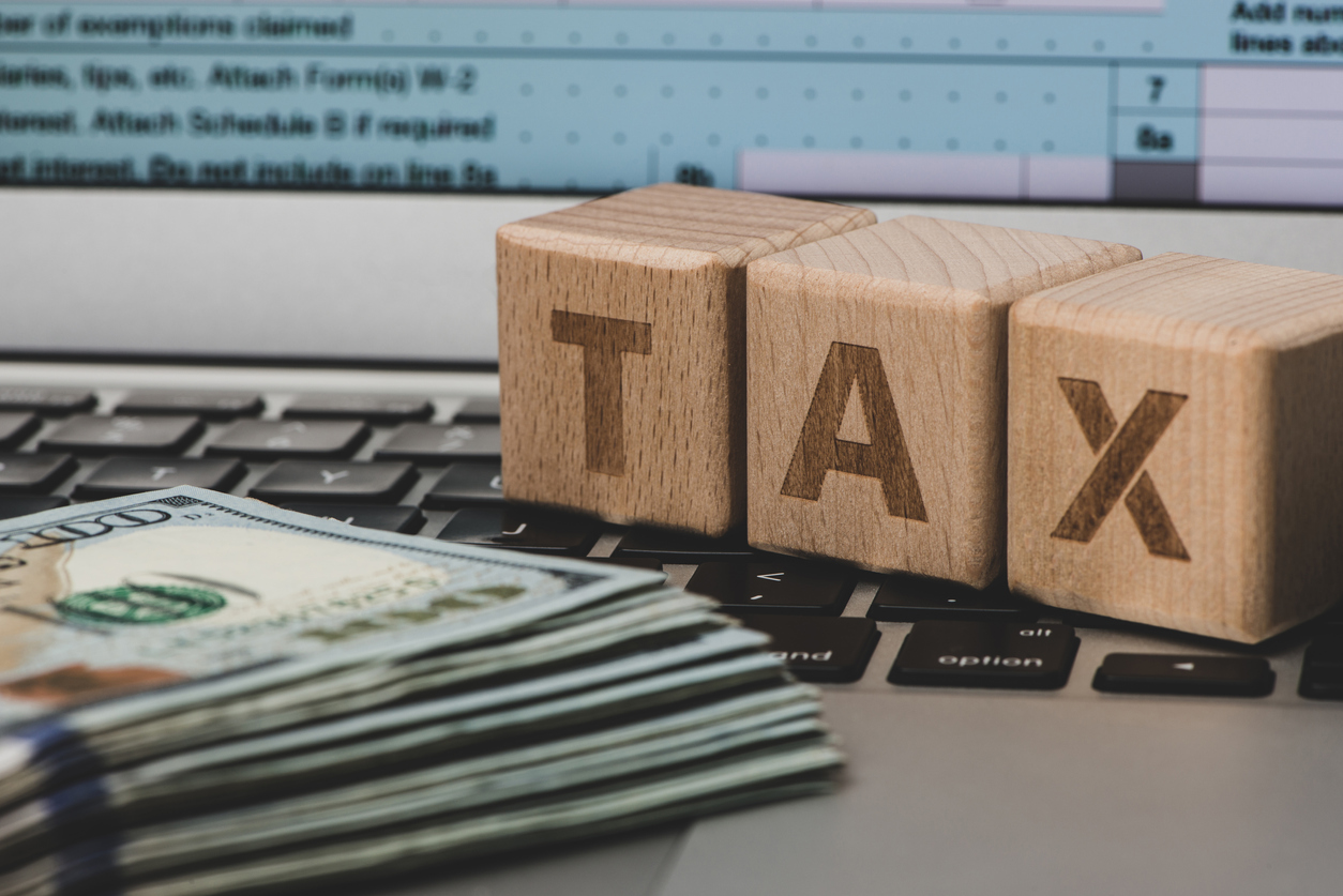 US currency notes and tablet computer. Filling online tax information. concept: Tax Levy