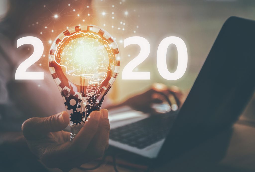 Número 2020 con mano y bombilla. Concepto: Mejor negocio para empezar en 2020