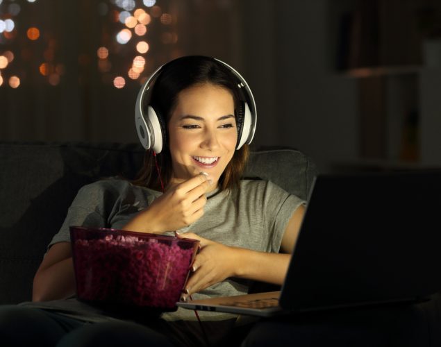 Mujer viendo películas desdesu computadora. Concepto: Las mejores películas de negocios para mujeres emprendedoras.
