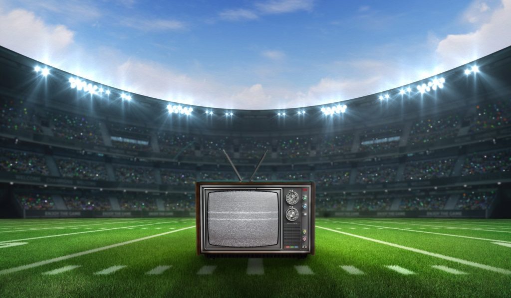 Estadio de footbal, fútbol, americano con una televisión en el centro. concept: anuncios super bowl