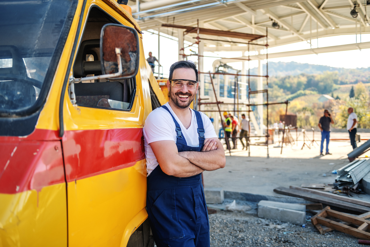 Worker leaning on company's truck and smiling to camera. Concept: Best auto loans for small businesses