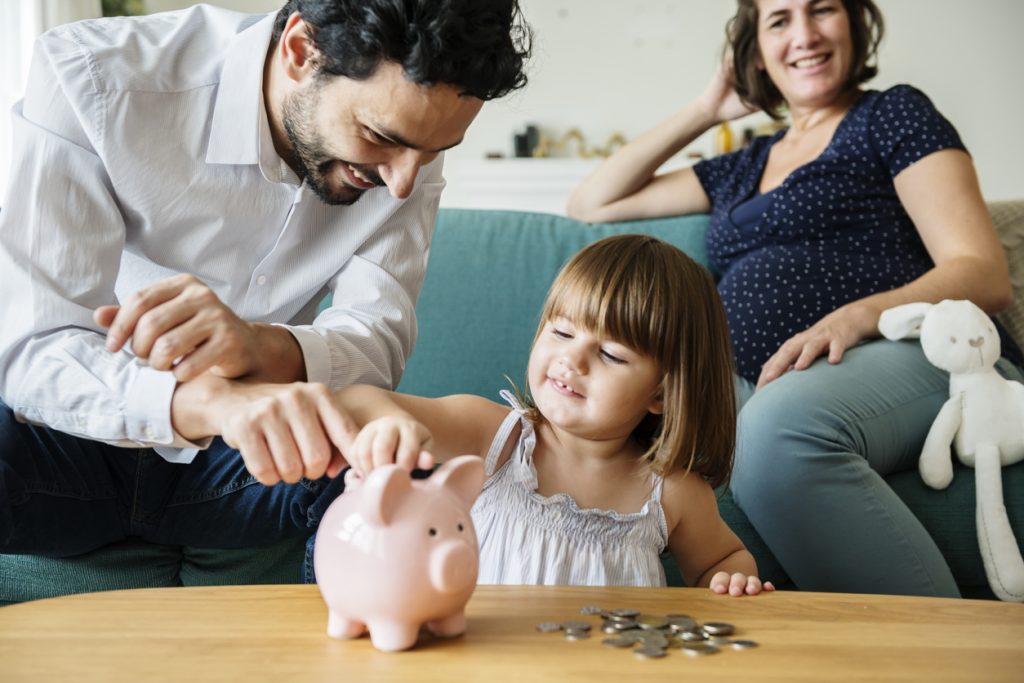 Family saving money in piggy bank. Concept: Types of business savings accounts