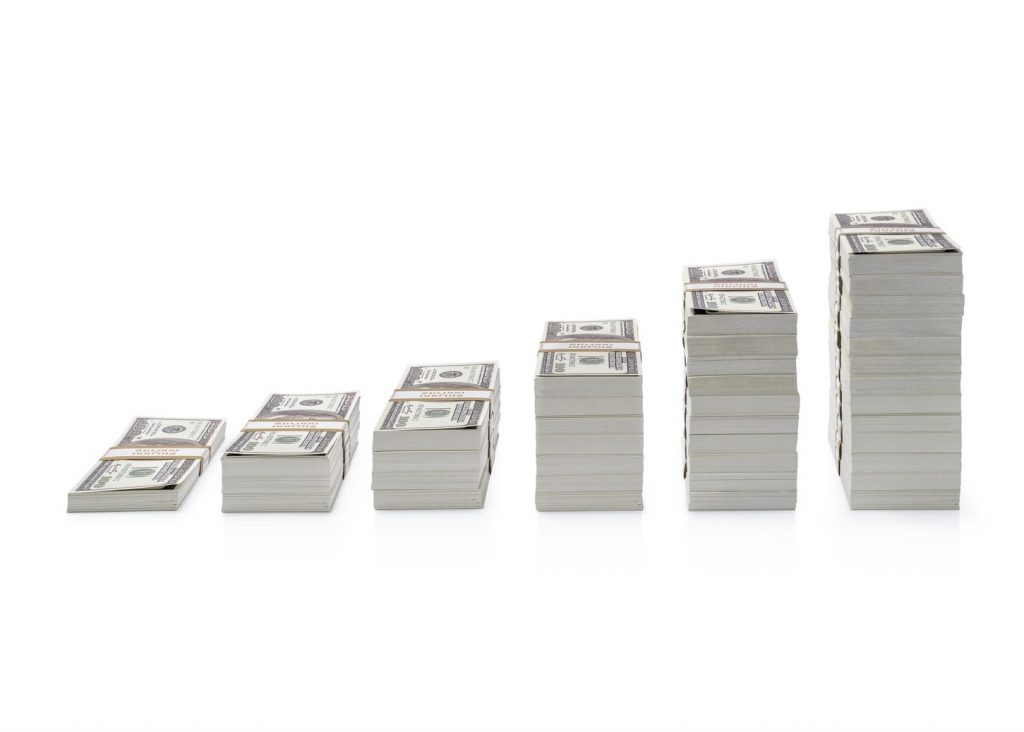 Increasing piles of dollar bills isolated on white background. concept: Compound Interest Accounts