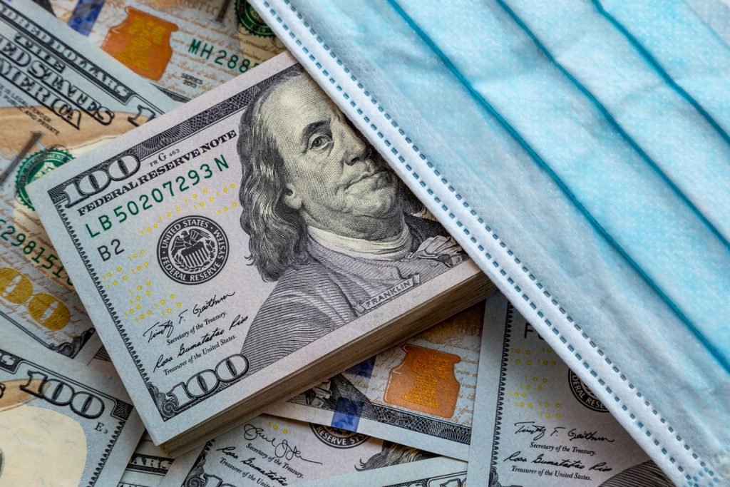 Dólares americanos con una mascarilla. concept: Programas de apoyo para pequeñas empresas por coronavirus de la SBA