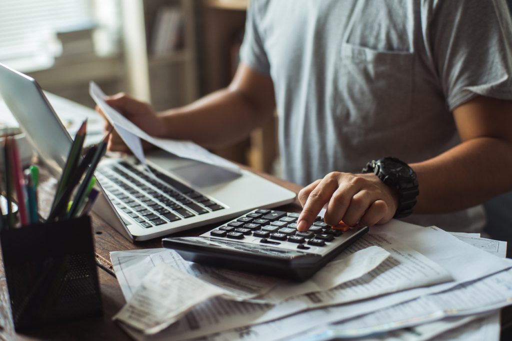 Hombre usando calculadora y gesitonando sus cuentas por cobrar