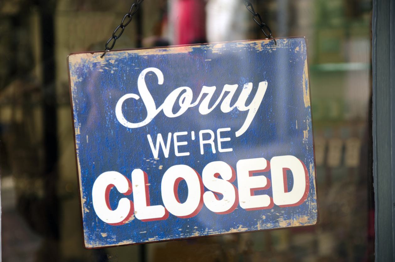 Old blue closed sign hanging in a shop window. Vintage closed sign in shop window. Concept: small businesses