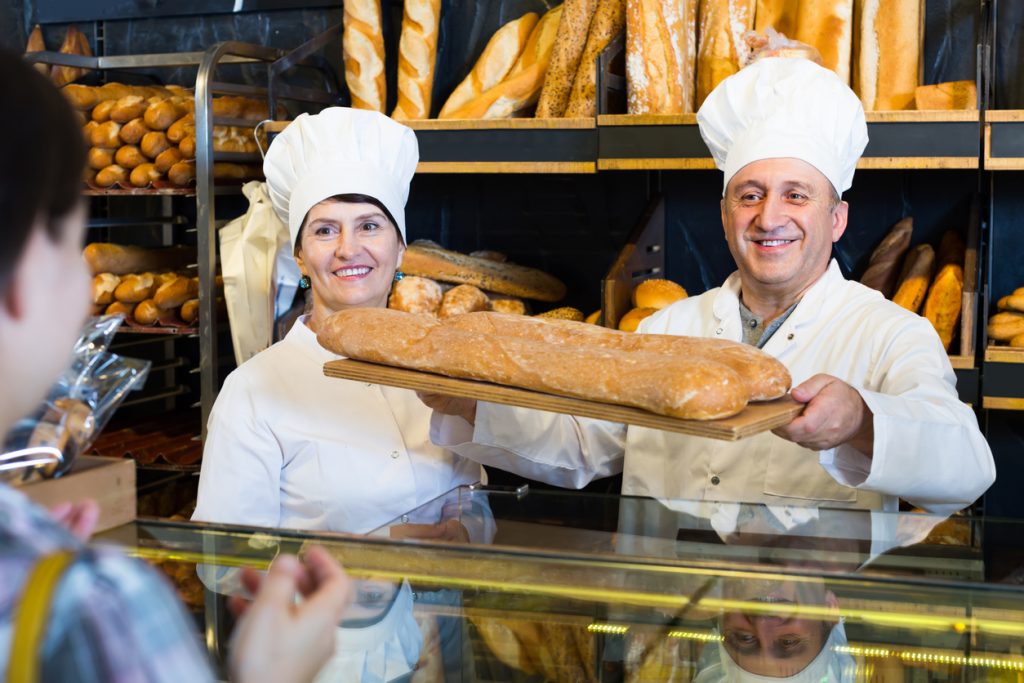 Dueños de panadería vendiendo pan fresco - negocio tradicional